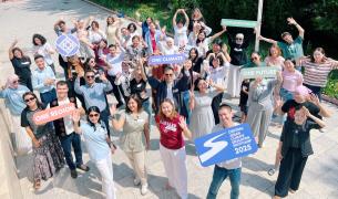 A group of adults stand outside. They are holding up signs that read "One Region," "One Climate," "One Future" and "Central Asian Climate Bootcamp 2025"